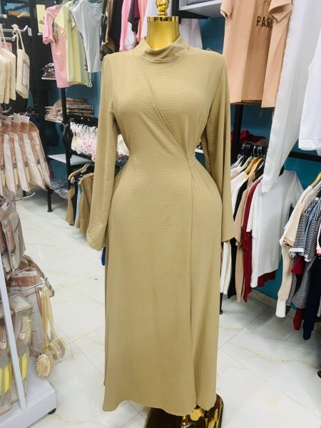 فستان بلون بيج هادئ، بتصميم أنيق يبرز الخصر